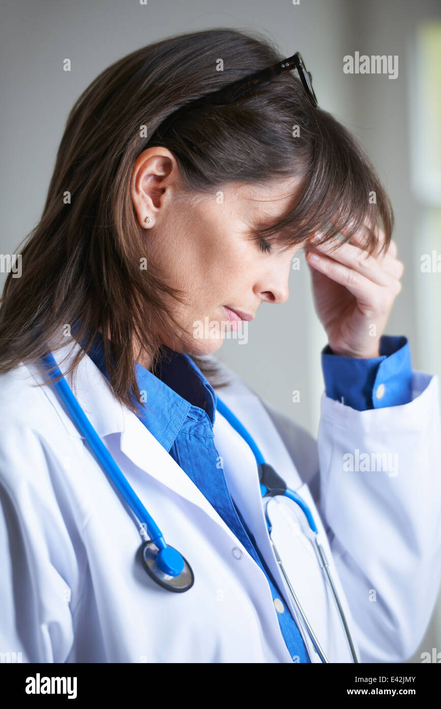 Doctor with hand on head, eyes closed Stock Photo
