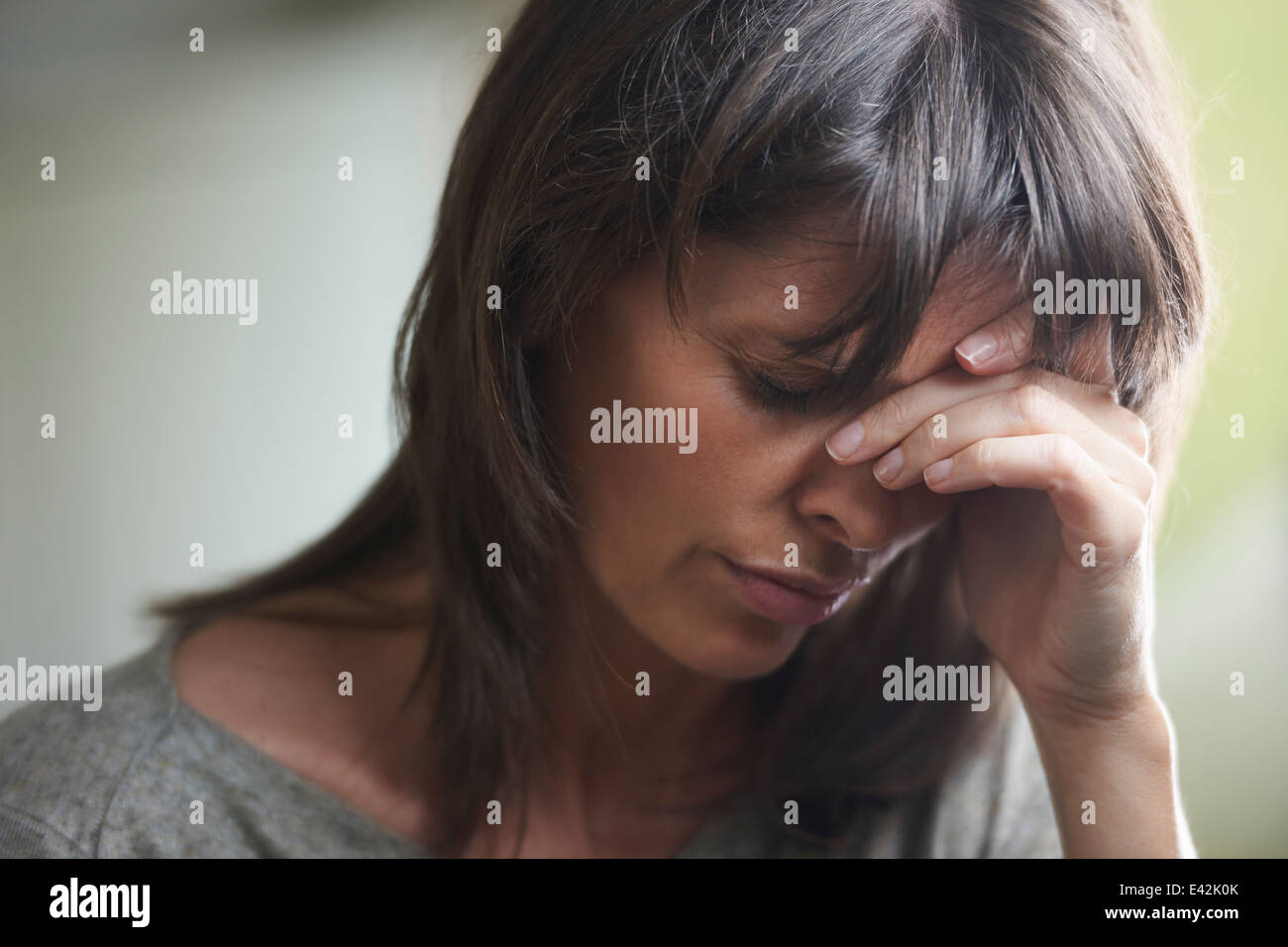 Mature woman with head in hands Stock Photo