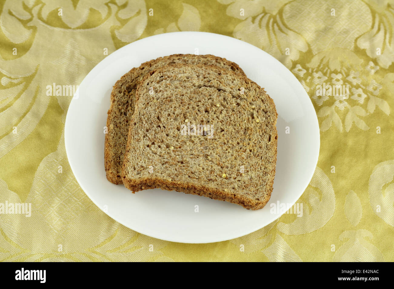 Two crisp whole sprouted grain and legume bread slices on a round white