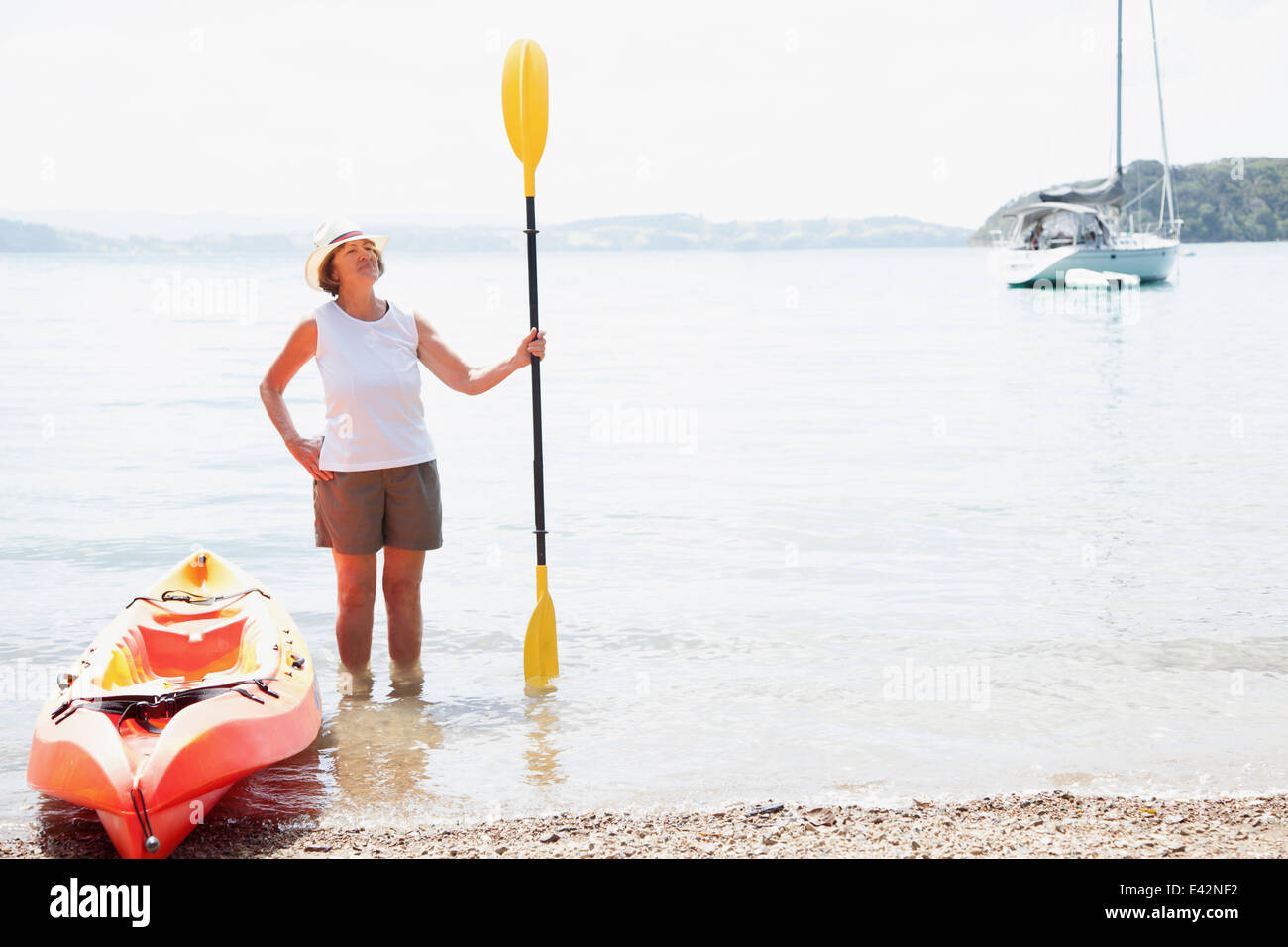 Senior woman with paddle and sea kayak Stock Photo