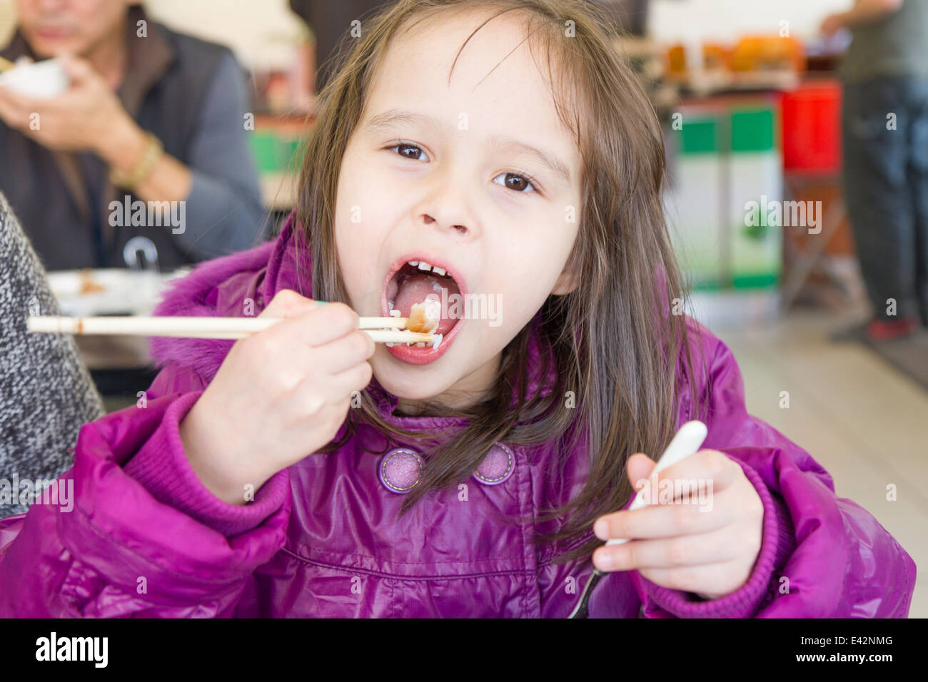 Young child eating food with Chinese chopsticks Stock Photo Alamy