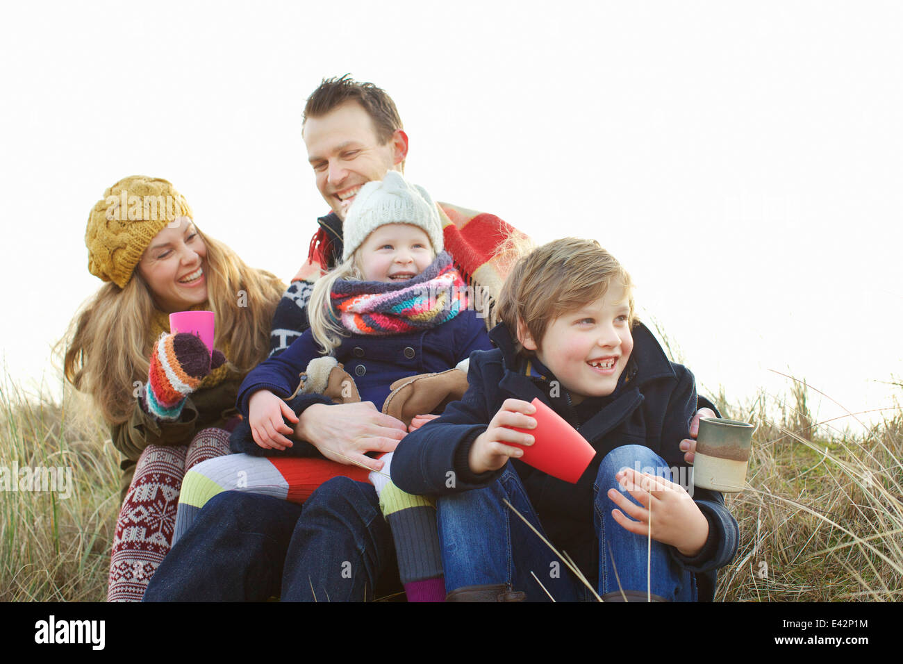 Smiling mid adult couple with two children at coast Stock Photo