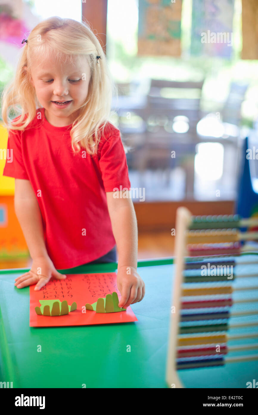 Girl counting with fingers at nursery school Stock Photo