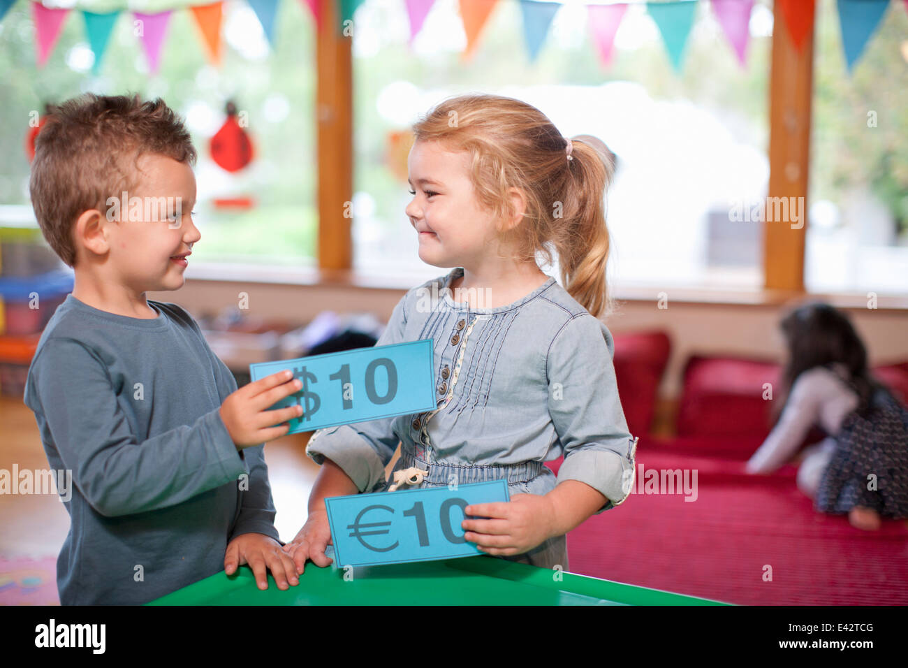 Boy and girl counting euro currency at nursery school Stock Photo