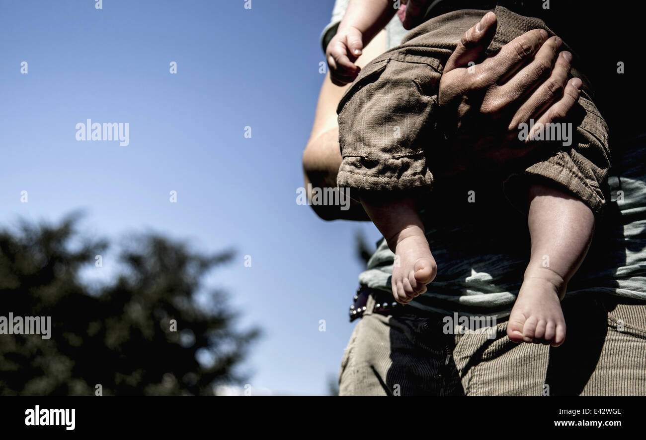 Cropped close up of young man carrying baby son Stock Photo