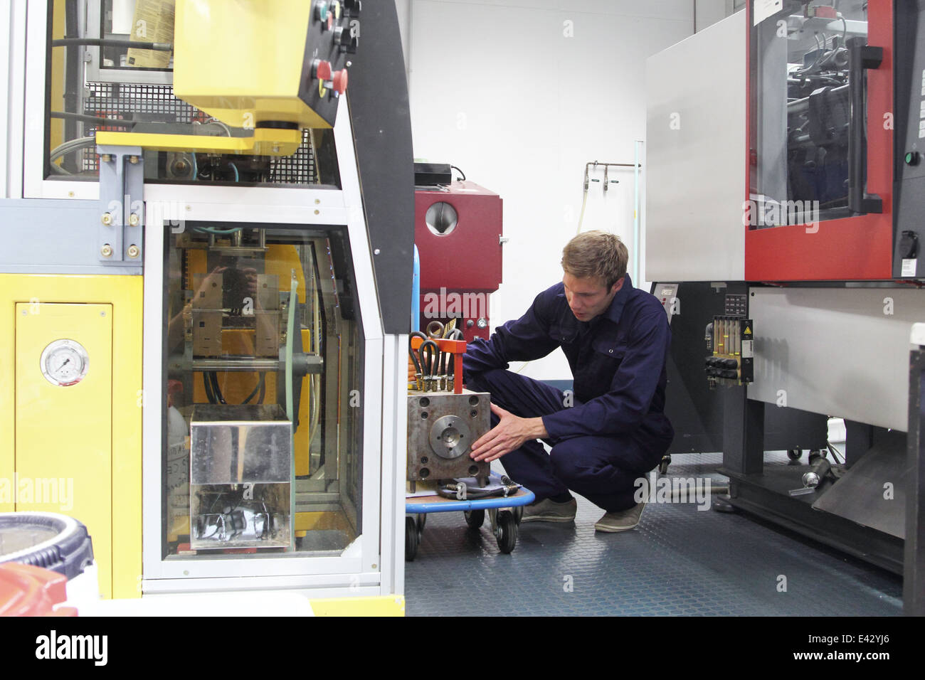 Male engineer repairing manufacturing machine in factory Stock Photo