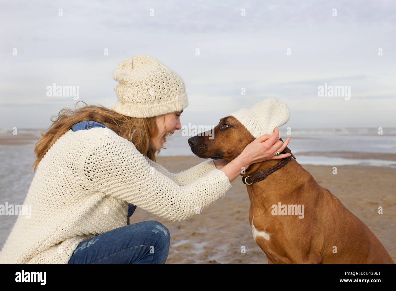 Portrait of mid adult woman and dog on beach, Bloemendaal aan Zee, Netherlands Stock Photo