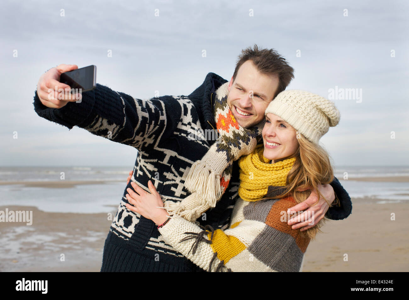 Mid adult couple taking selfie with smartphone on beach, Bloemendaal aan Zee, Netherlands Stock Photo