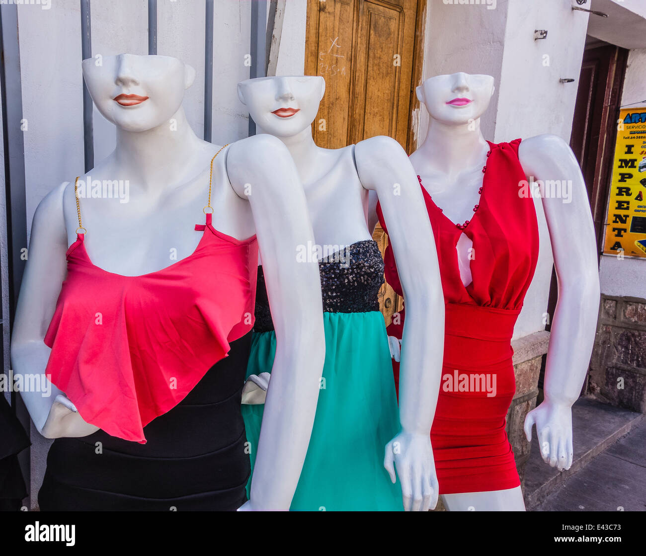 Three white colored mannequins, whose heads are only half a head missing  the top from the eyes up, displaying woman's clothes Stock Photo - Alamy