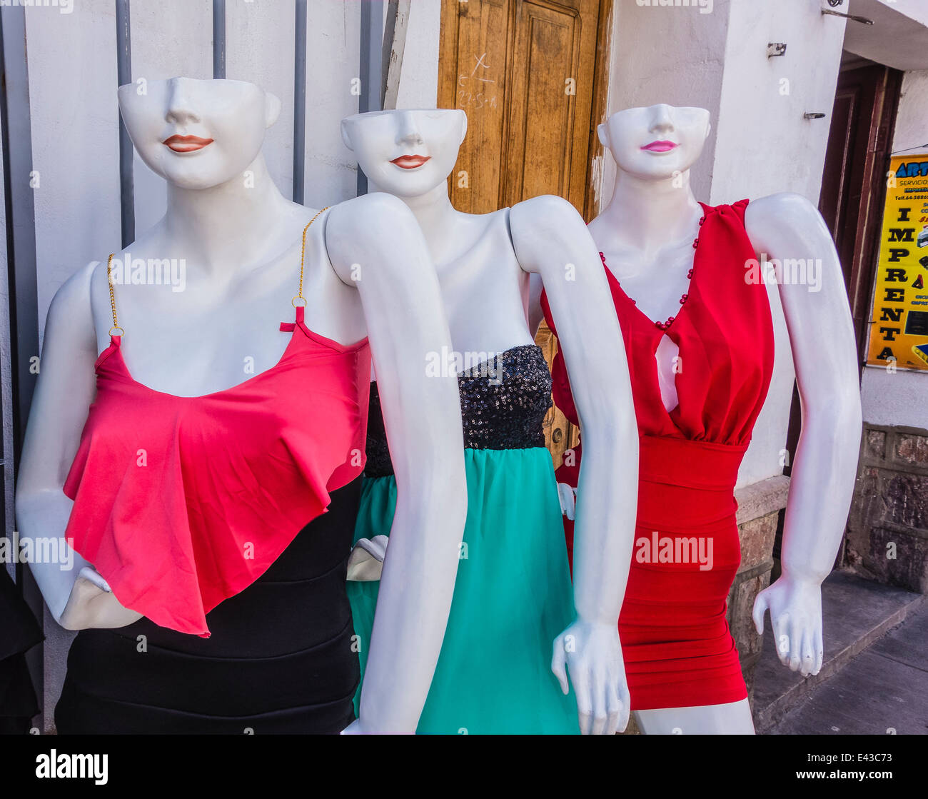 Three white colored mannequins, whose heads are only half a head