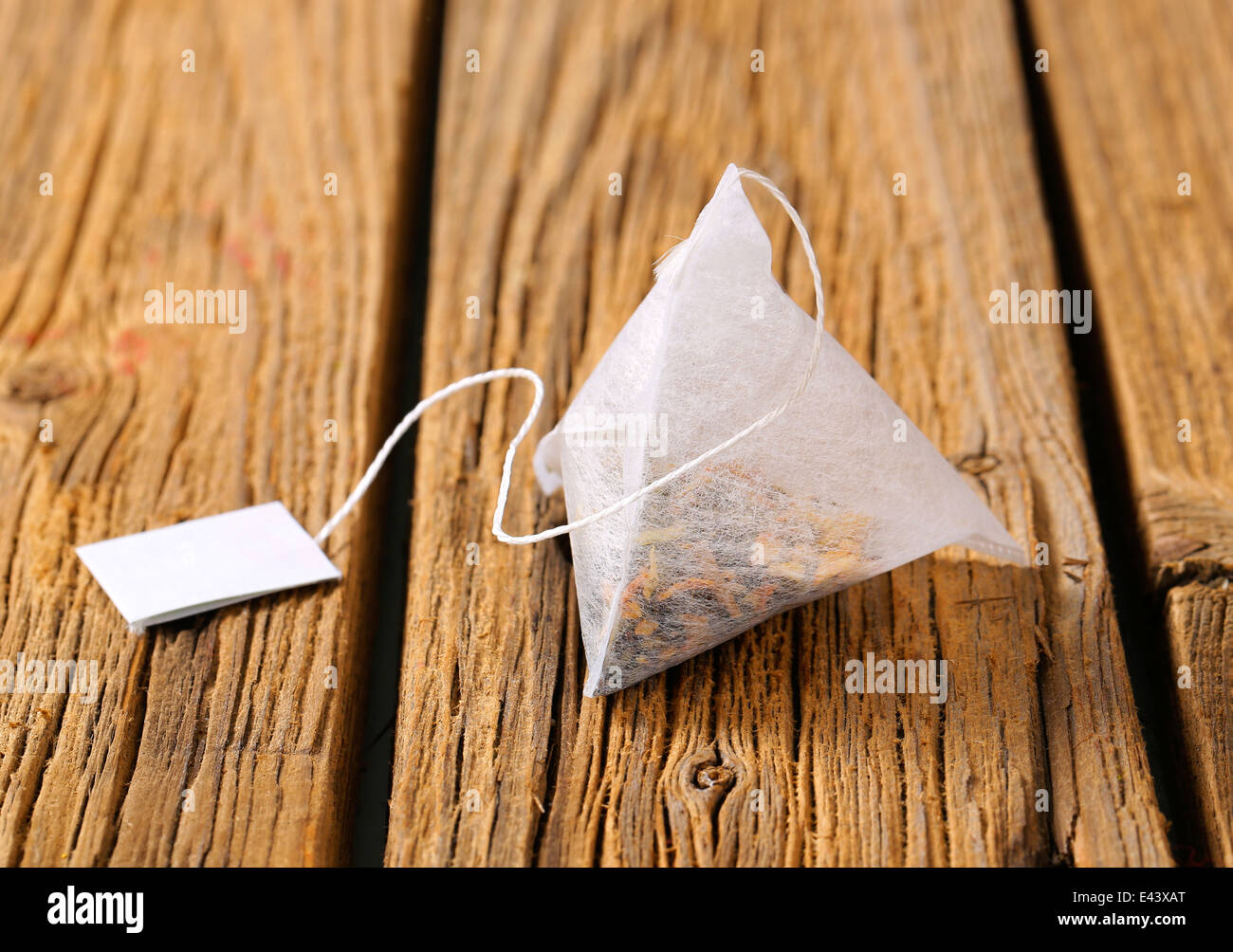 Pyramid-shaped tea bag on wood Stock Photo