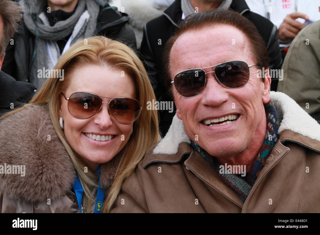 Arnold Schwarzenegger and girlfriend Heather Milligan sitting in the VIP grandstand at the 2014 FIS Alpine World Cup  Featuring: Arnold Schwarzenegger,Heather Milligan Where: Kitzbuehel, Austria When: 25 Jan 2014 Stock Photo