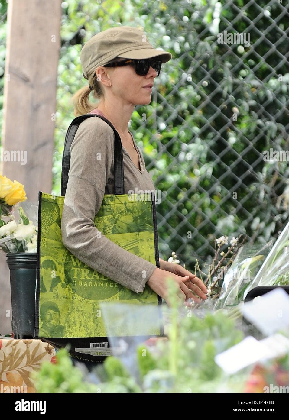 Naomi Watts wearing a casual beige top layered over a pink vest and