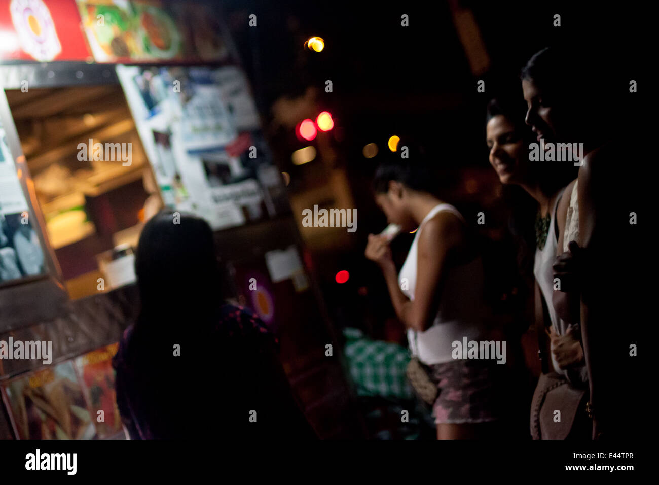 Girls at night in front of hot dog stand in New York City. Stock Photo