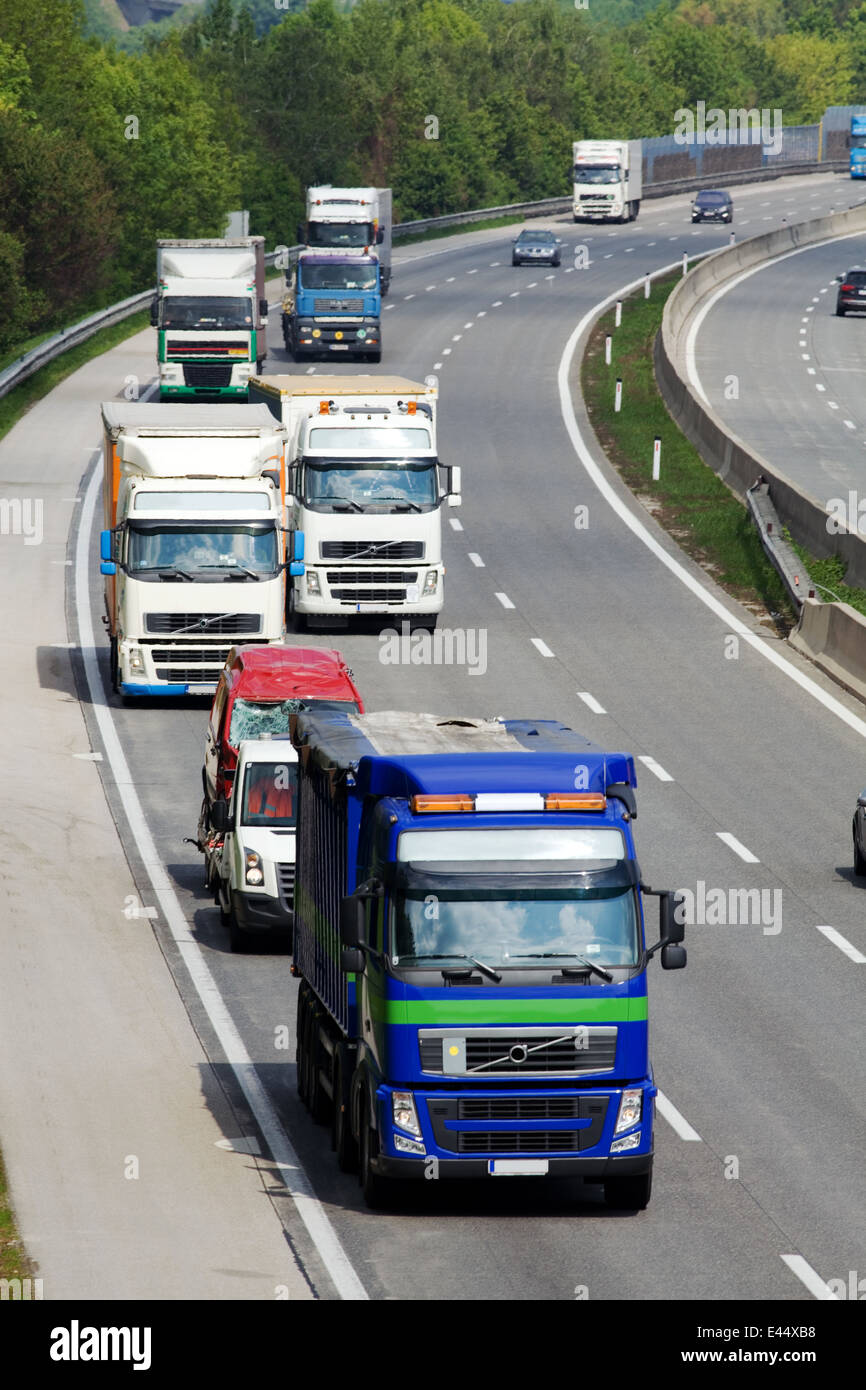 On a highway trucks and cars driving side by side Stock Photo - Alamy