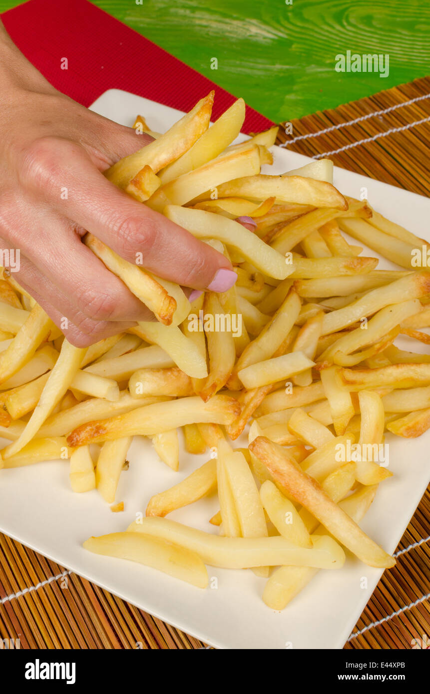 Female Hand Grabbing Greasy French Fries From A Plate Stock Photo Alamy
