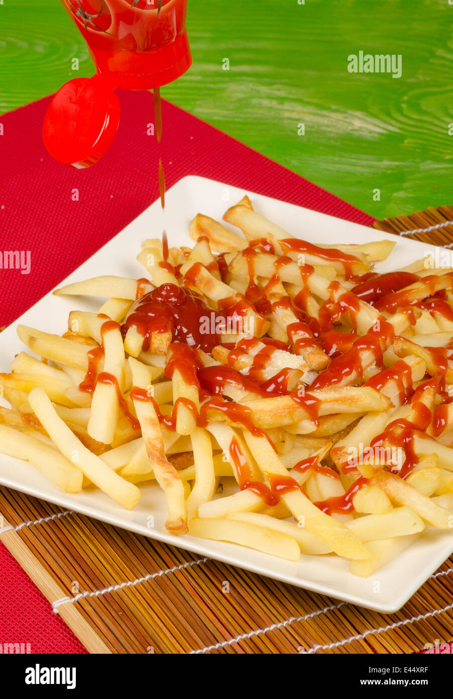 Pouring lots of ketchup on a serving of French fries Stock Photo Alamy