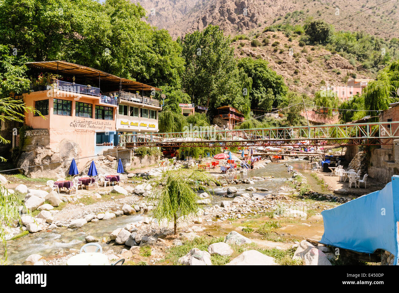 Plastic patio tables, chairs with parasols at restaurants on the banks of the Ourika River, Ourika Valley, Atlas Mountains, Morocco Stock Photo