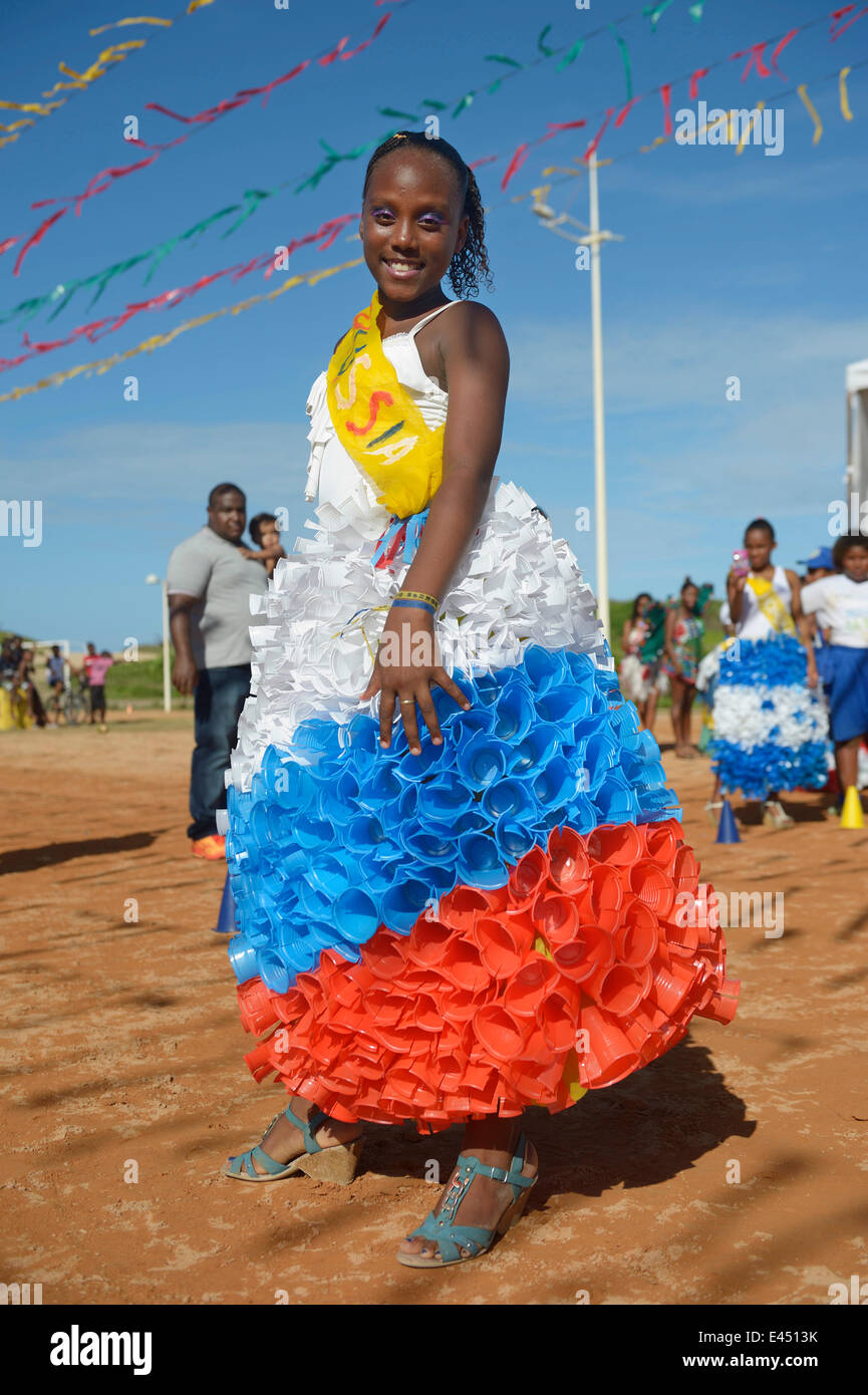 Teenage girl presenting a dress made of recycled disposable plastic cups at a fashion show of a social project Stock Photo