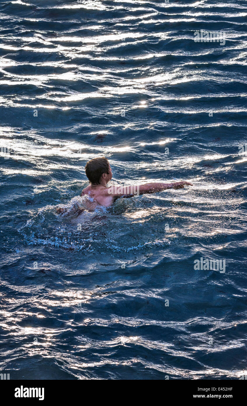 Man swimming in rough waters. Stock Photo