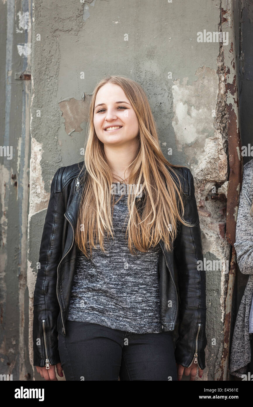 Teenage girl leaning against wall Stock Photo