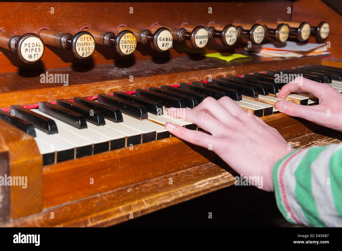 A 14 year old boy playing a pipe organ inside a UK church Stock Photo