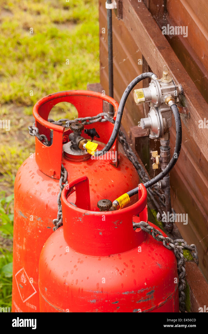 Propane gas cylinders fitted externally to a wooden building in the Uk Stock Photo