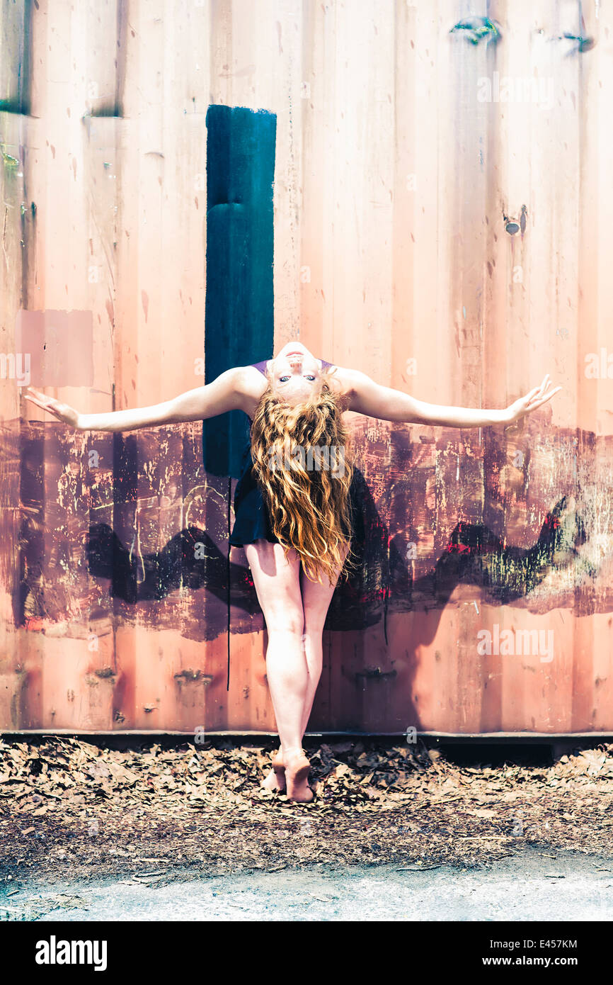 Modern dancer striking a pose in front of an abandoned shipping container Stock Photo