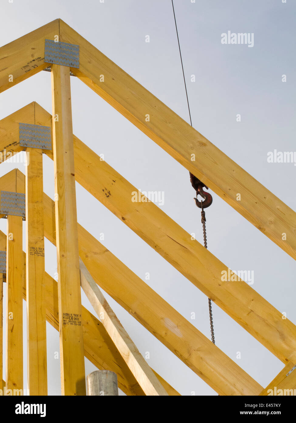 self building house, constructing roof, lifting roof trusses into