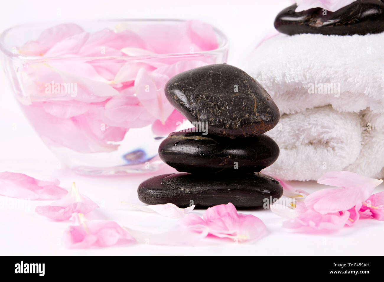 Spa stones with rose petals on white background Stock Photo - Alamy