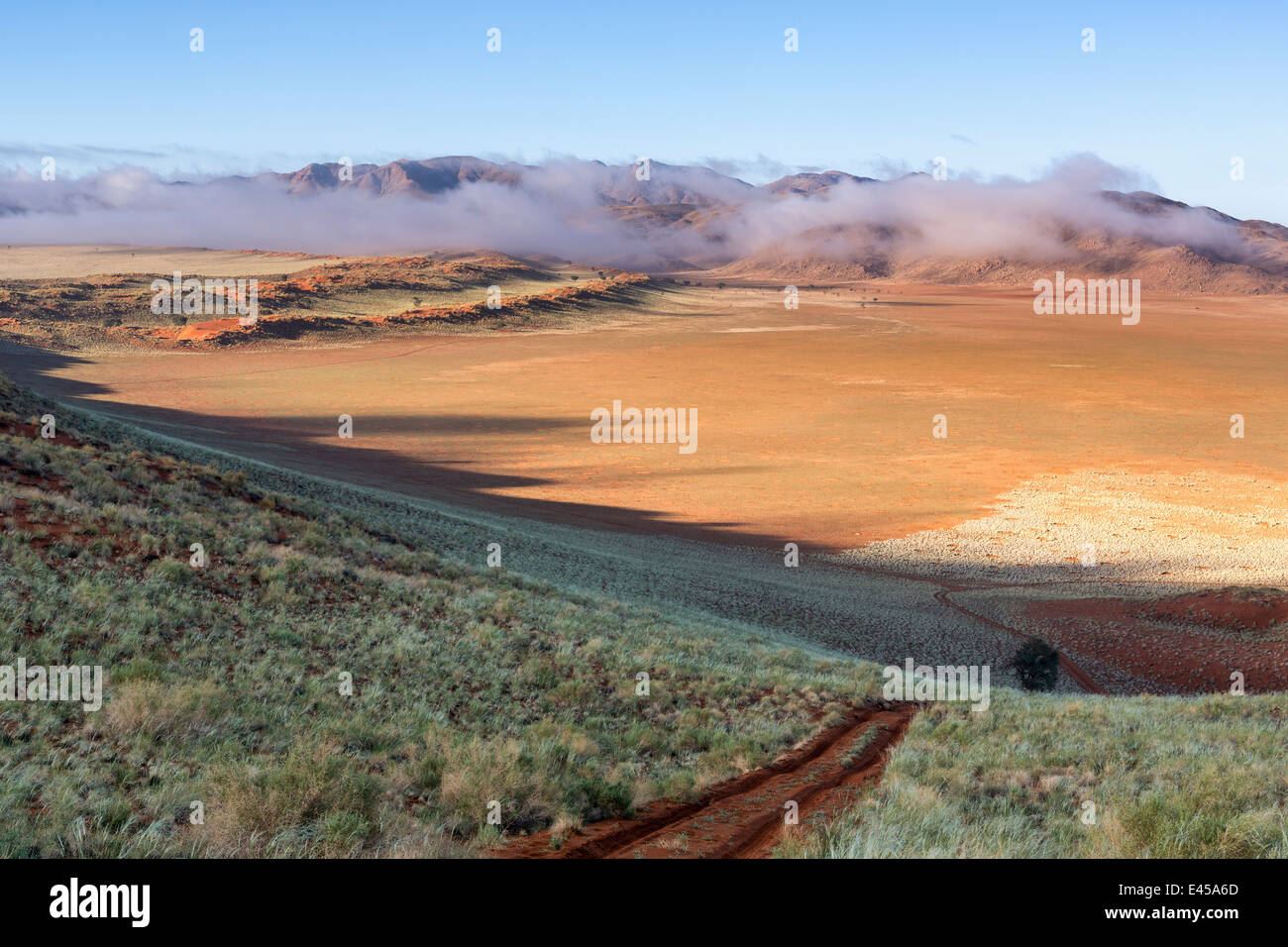 Sand road in the Namib-Naukluft Park,with mountains and low clouds Stock Photo