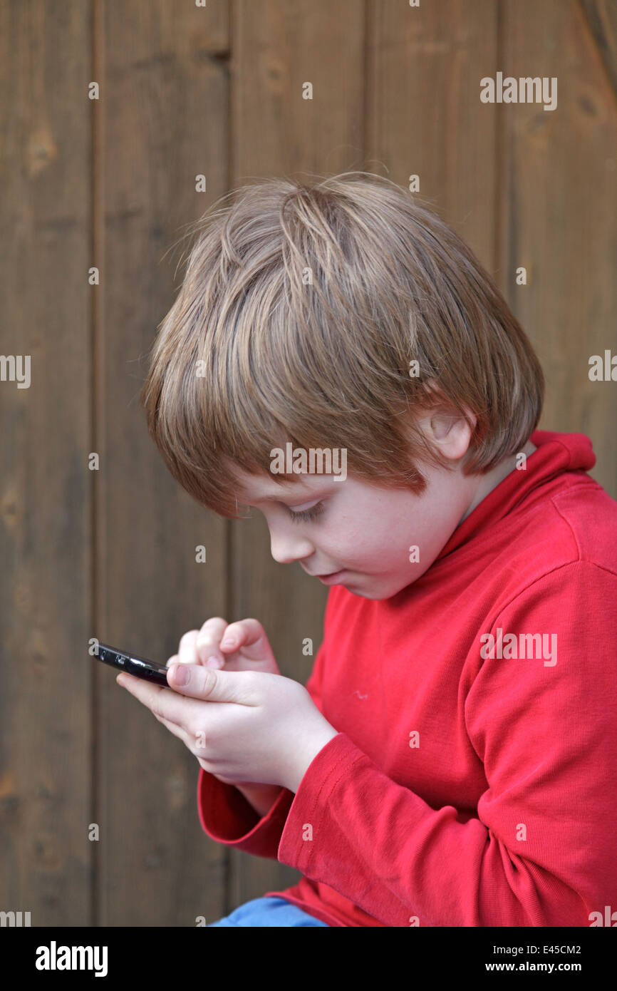 young boy writing a text message on a mobile phone Stock Photo - Alamy