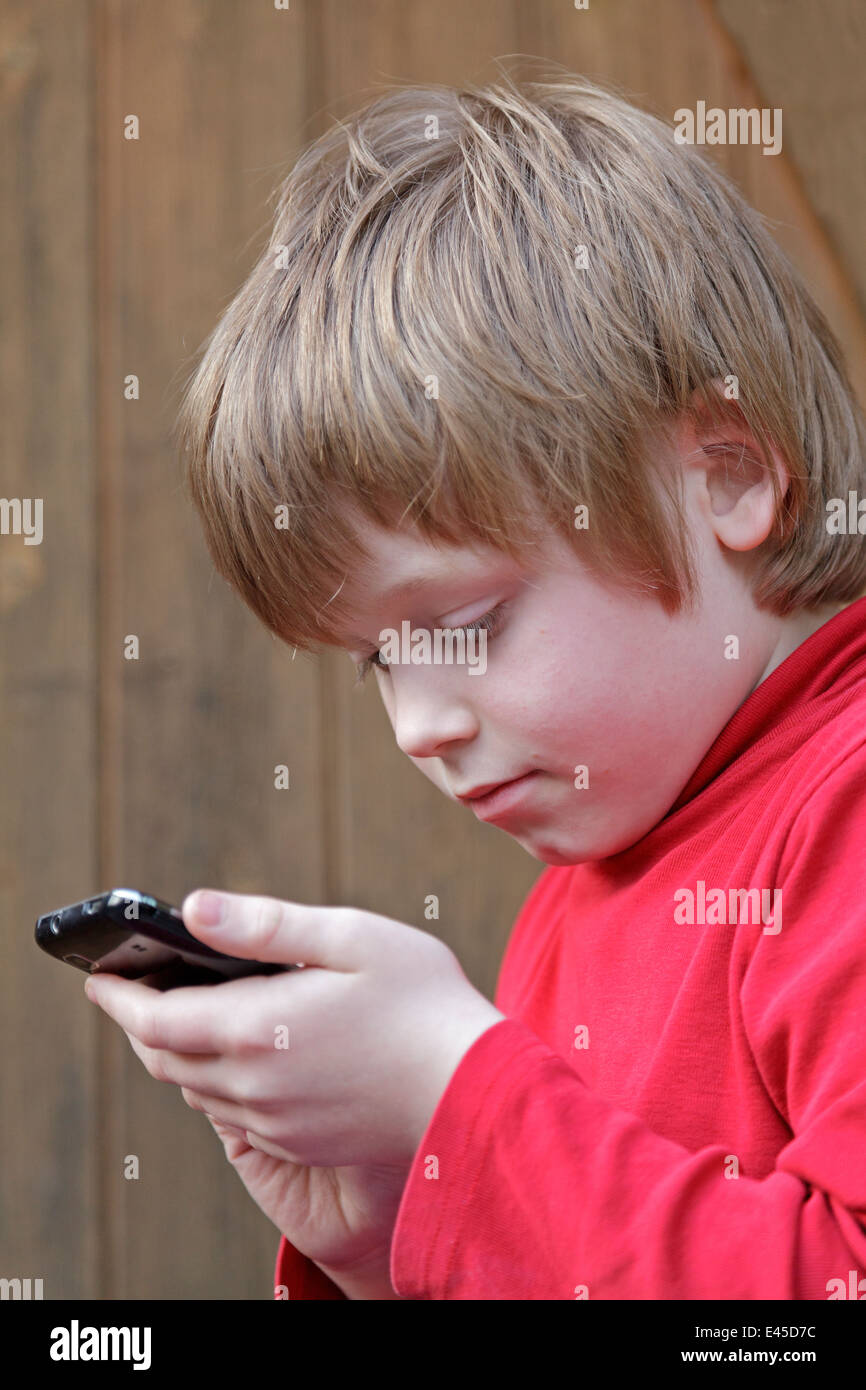 young boy writing a text message on a mobile phone Stock Photo - Alamy
