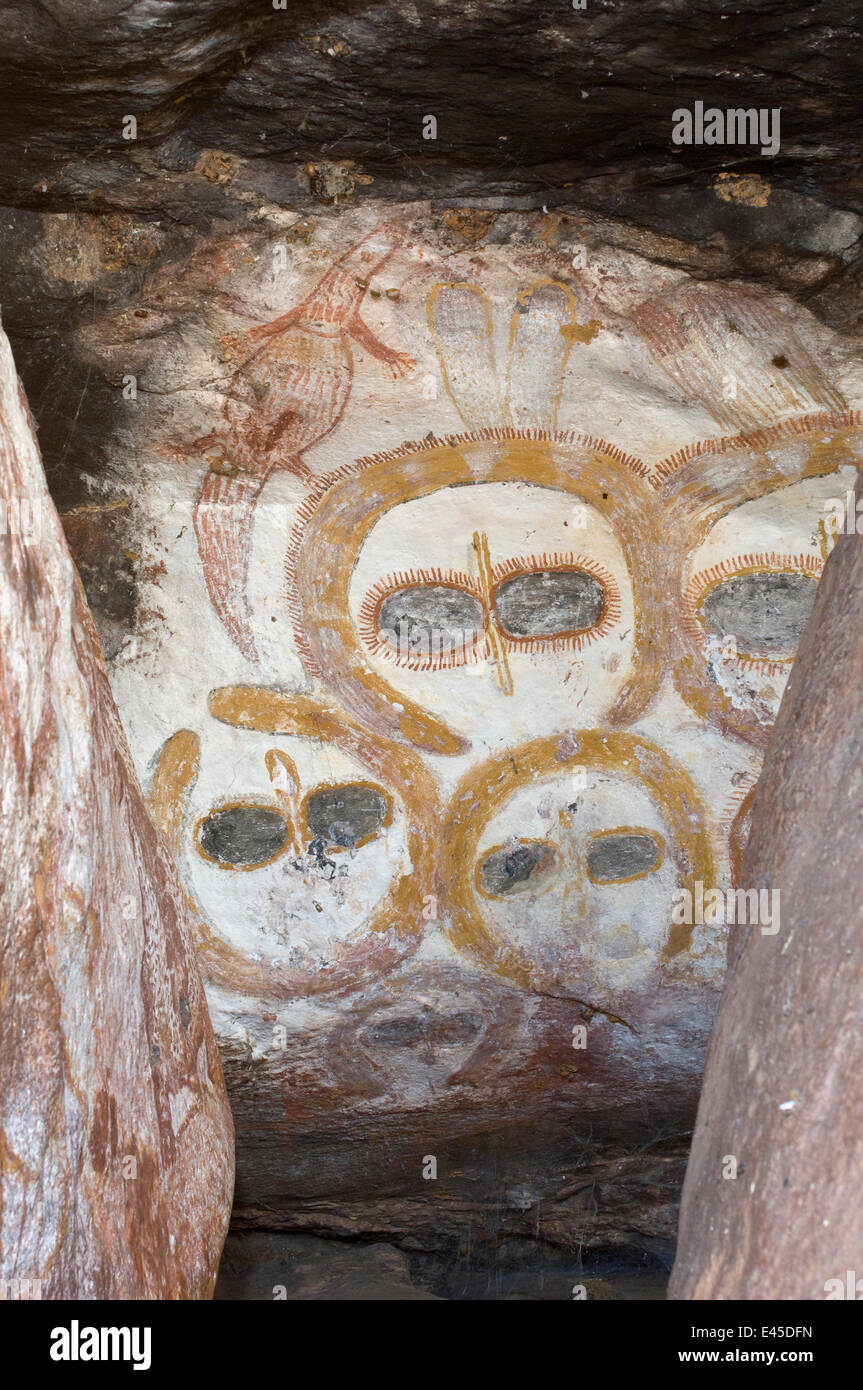 A rock art shelter in the northern Kimberley region features a cluster of Wandjina figures peering out from the sandstone rock surface, Northern Kimberley region and the Mitchell Plateau, Western Australia Stock Photo