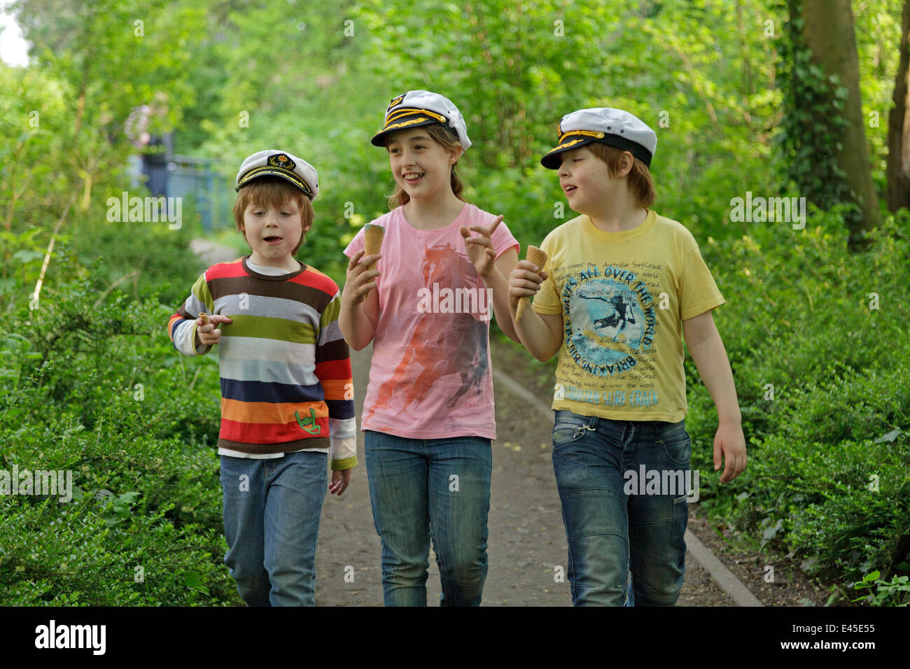three children with captain´s hats having a conversation Stock Photo