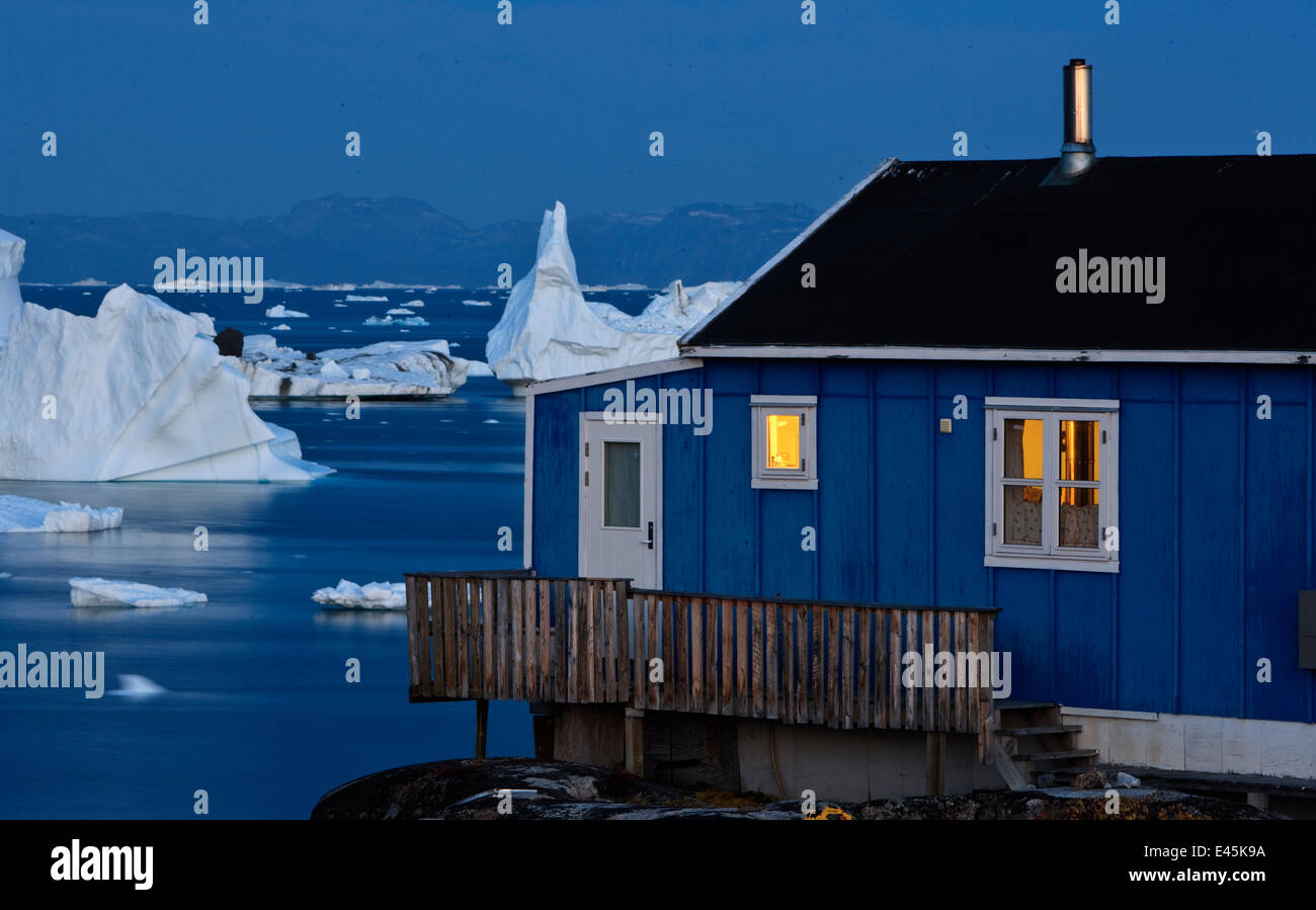House on the coast with icebergs in the distance, Saqqaq, Greenland, August 2009 Stock Photo Alamy