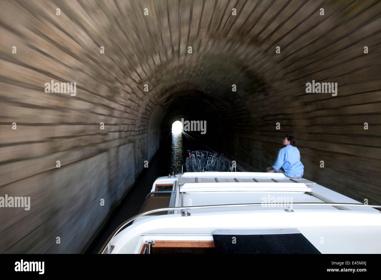 Woman on boat passing through a tunnel on the Canal Du Midi near Capestang, Languedoc, France. July 2009. Model and property released. Stock Photo