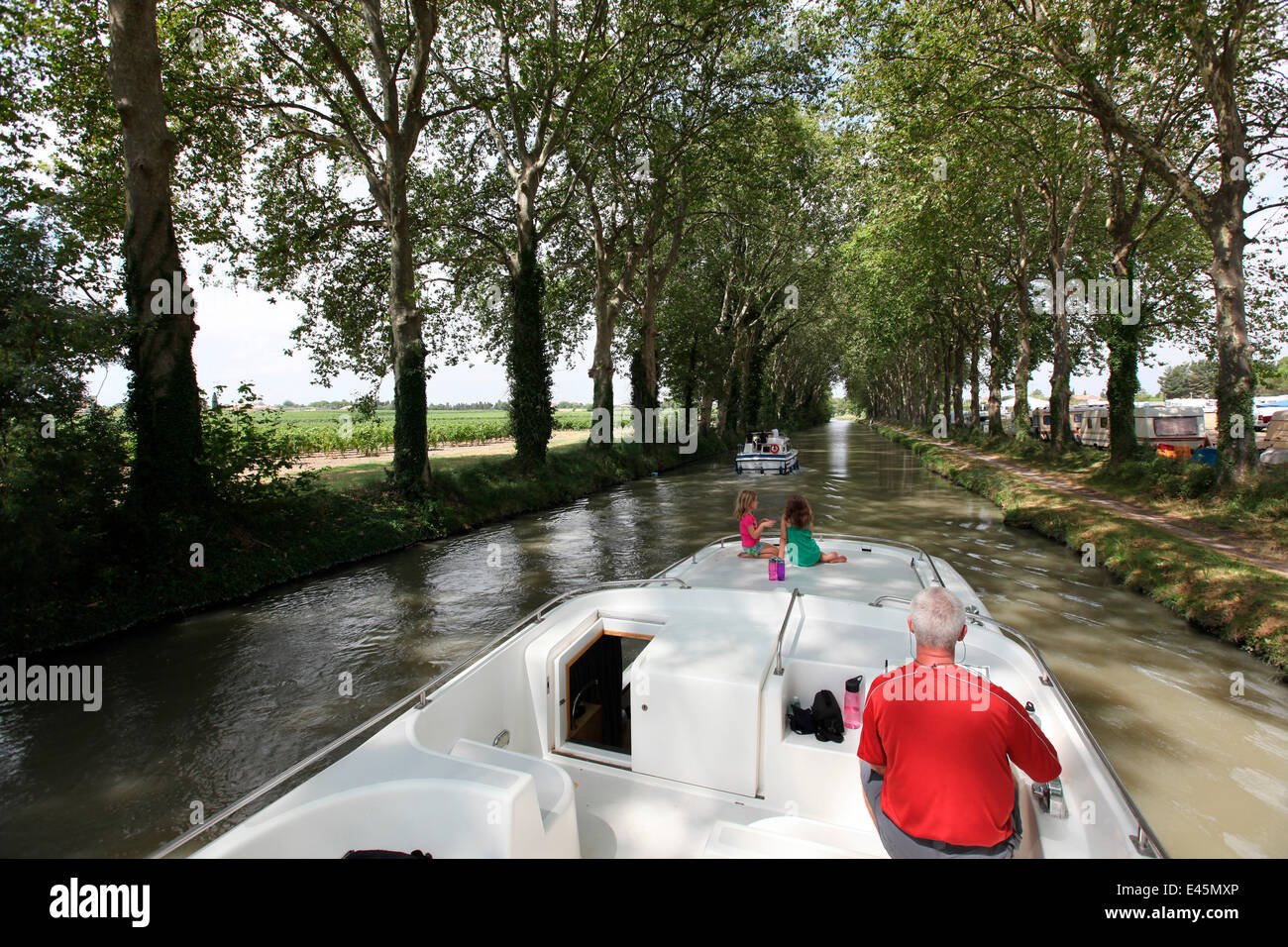 Family cruising on the Canal Du Midi near Capestang, Languedoc, France. July 2009. Model and property released. Stock Photo