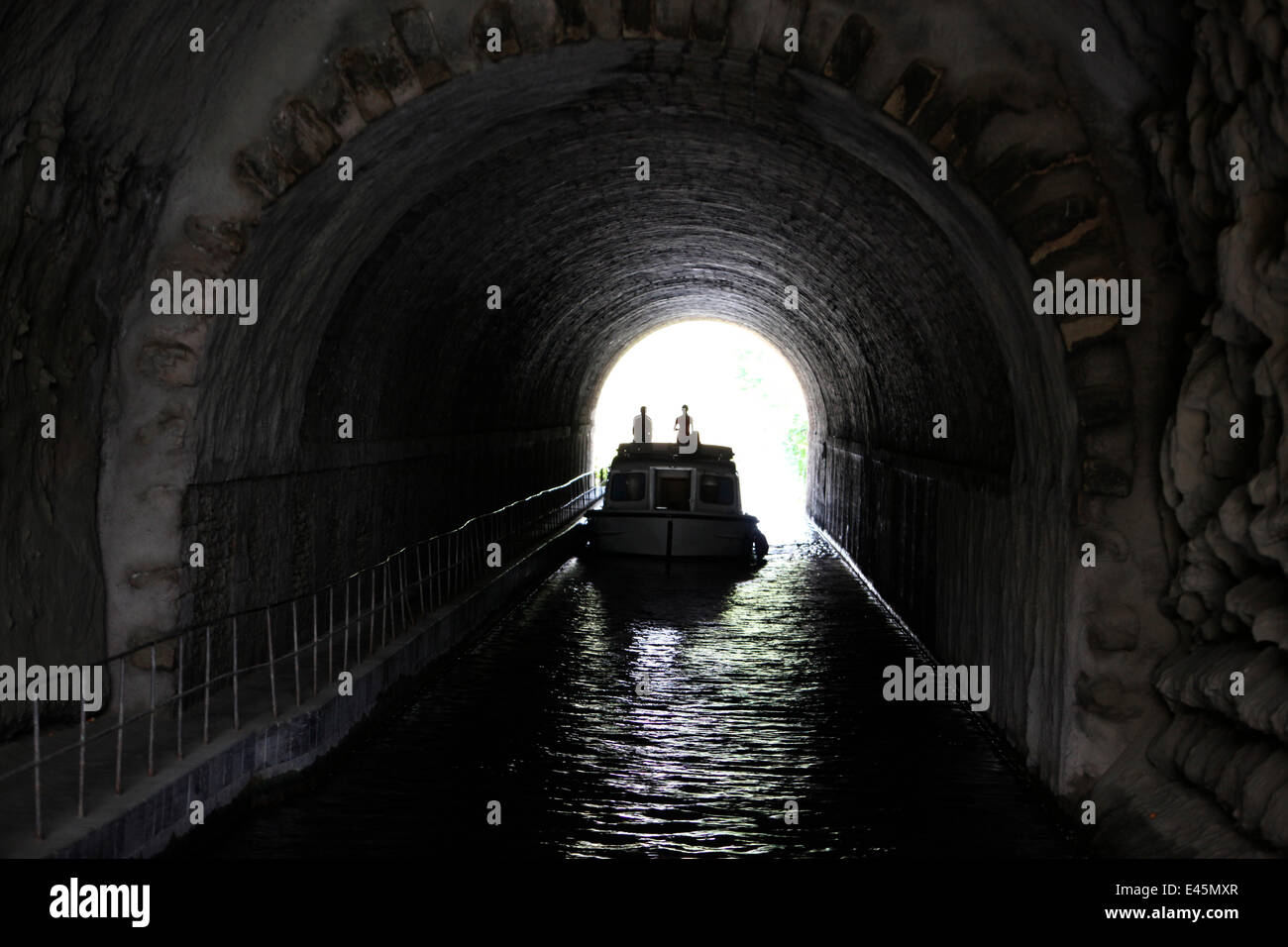 Boat passing through a tunnel on the Canal Du Midi near Capestang, Languedoc, France. July 2009. Model and property released. Stock Photo