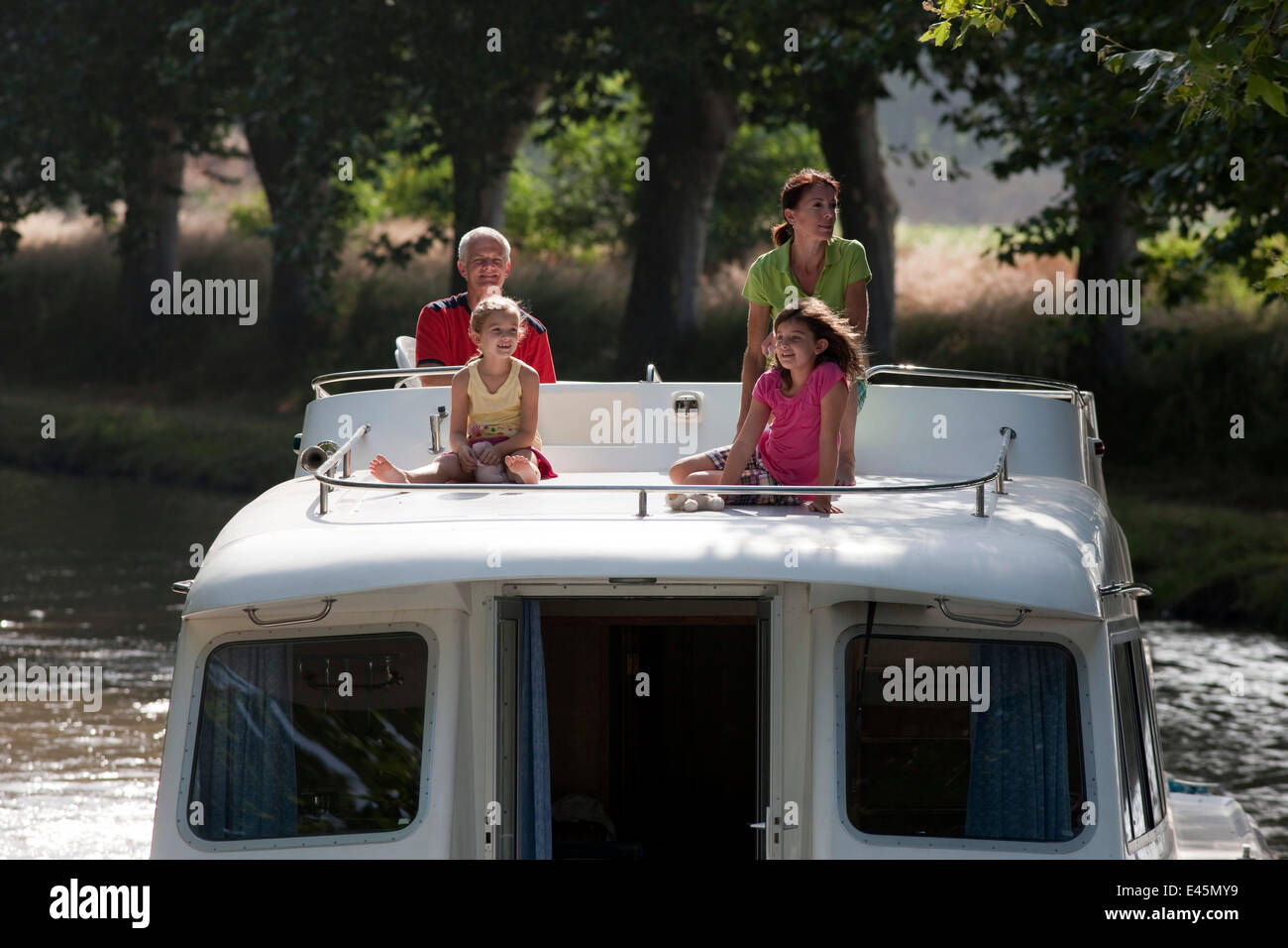 Family cruising on the Canal Du Midi near Aiguille, southern France. July 2009. Model and property released. Stock Photo