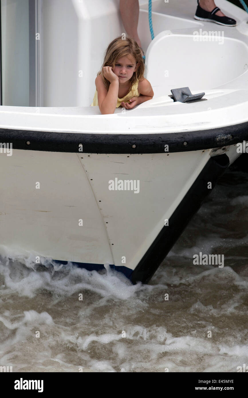 Little girl on bow of boat cruising on the Canal Du Midi near Homps, southern France. July 2009. Model and property released. Stock Photo