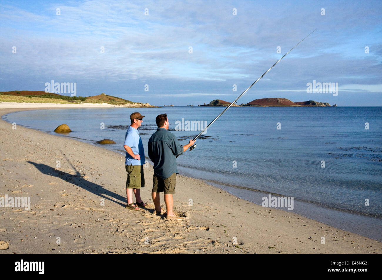 Two men fishing on Par Beach, St. Martin's, Isles of Scilly, UK, September. Model Released. Stock Photo