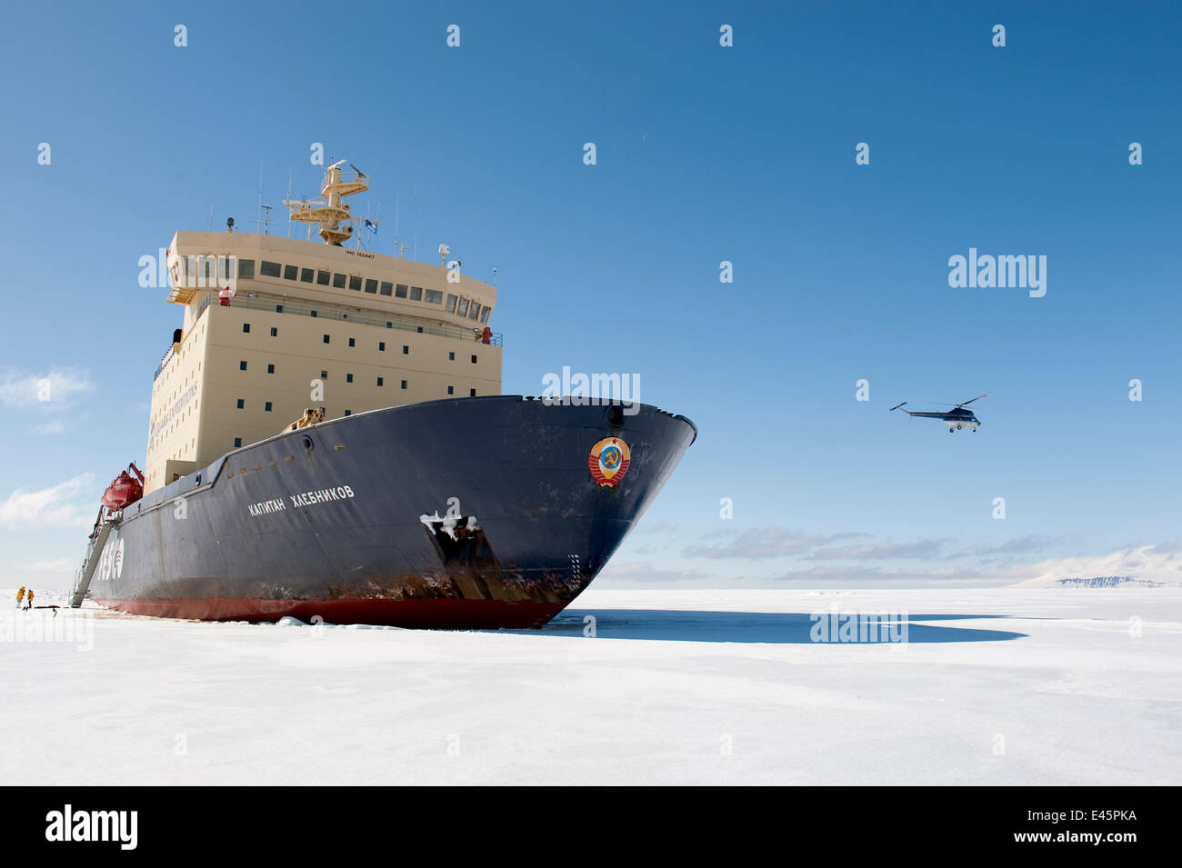 People disembarking from a Russian ice breaker ship, Kapitan Khlebnikov, amongst sea ice on a Quark expedition, Helipcopter flying in background, Ross Sea, Antarctica, November 2008 Stock Photo