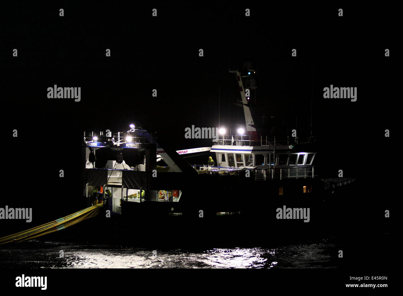 Fishing vessel Harvester hauling fishing gear in the dark  May 2010. Property released. Stock Photo