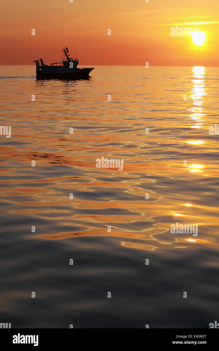 Trawling on the North Sea in calm conditions at sunset, May 2010. Property released. Stock Photo