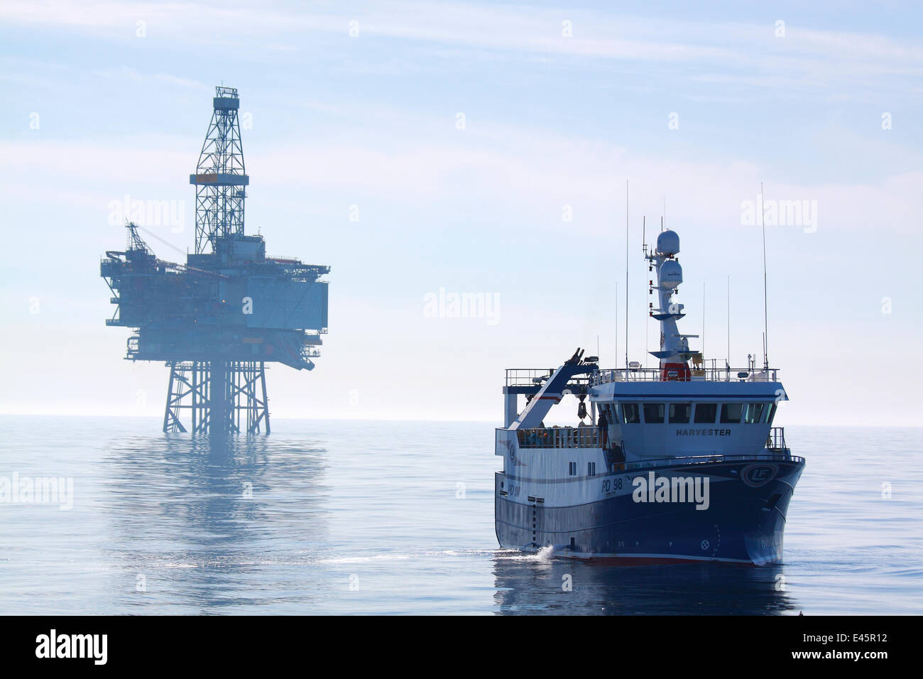Fishing vessel 'Harvester' and the 'Jotun B' oil production platform. North Sea, May 2010. Stock Photo