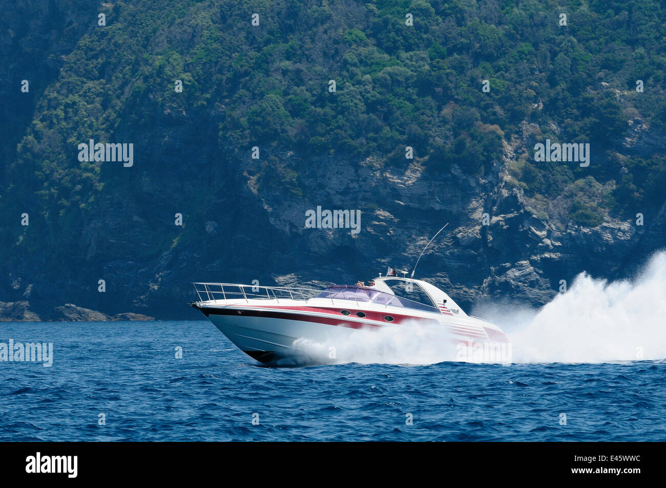 Speedboat heading along the Cote d'Azur past cliffs of the Giens Peninsula. France, May 2010. Stock Photo