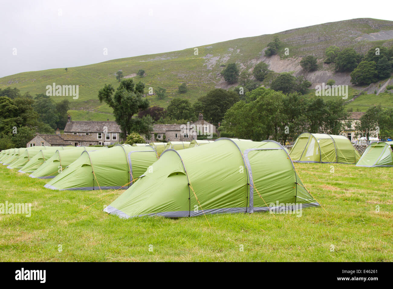 Pre-pitched tents in a field, rental camping accommodation in Kilnsey, Yorkshire Dales, July, 2014. Campers arrive and make preparations for the Tour de France. Thousands of cyclists have been in the Yorkshire Dales travelling the route of the Grand Depart. The fields assigned to parking and camping are now beginning to fill up in preparation for the cycling event on Saturday. Stock Photo