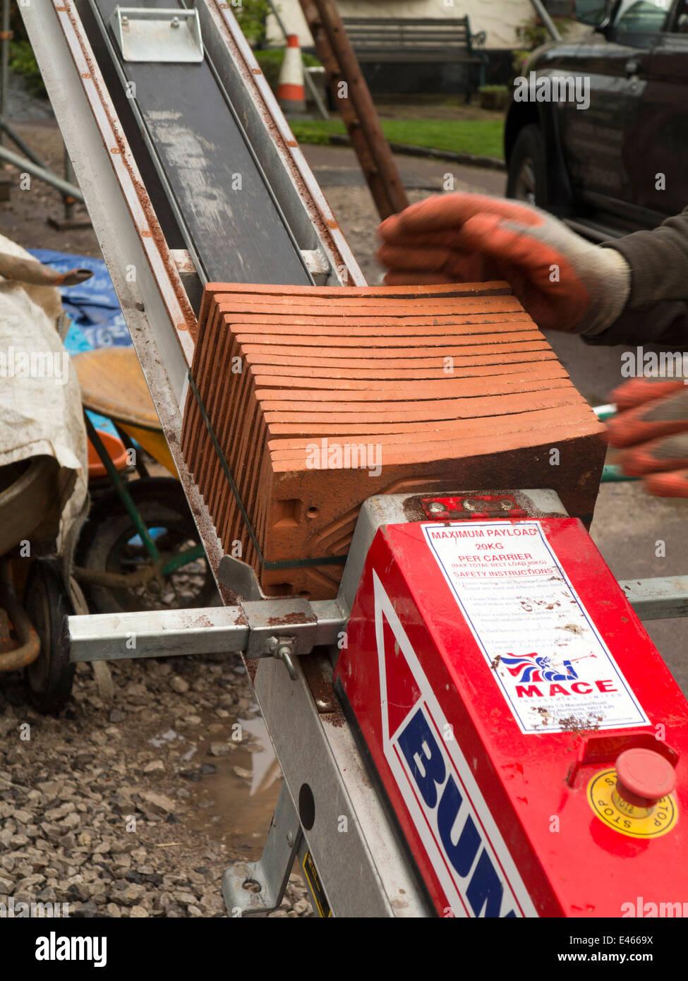 self building house, loading Bumpa lift to elevate clay roofing tiles to scaffolding Stock Photo
