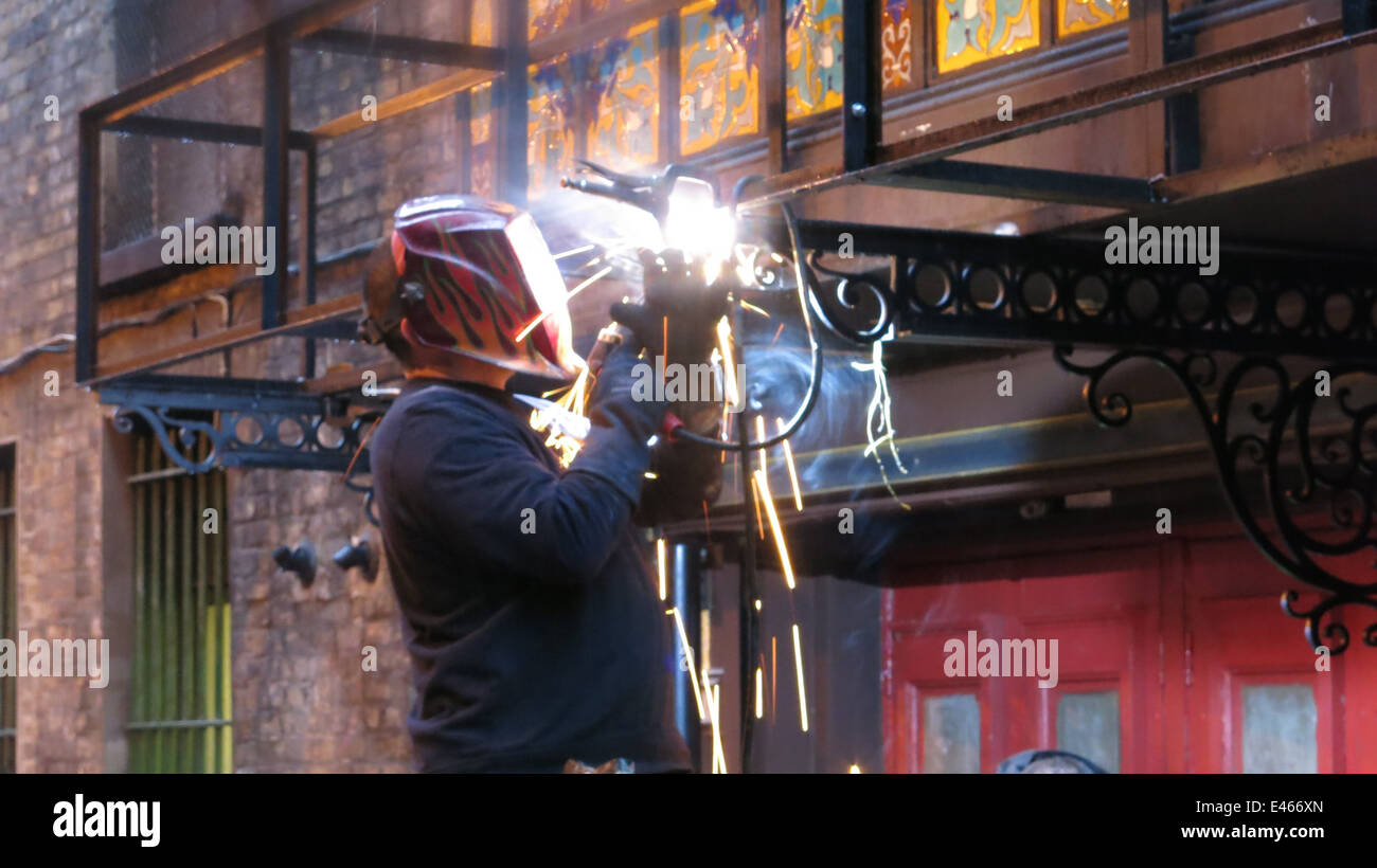 A welder at work during the pre-production of an on the street set for Victorian horror tv series 'Penny Dreadful'. Stock Photo